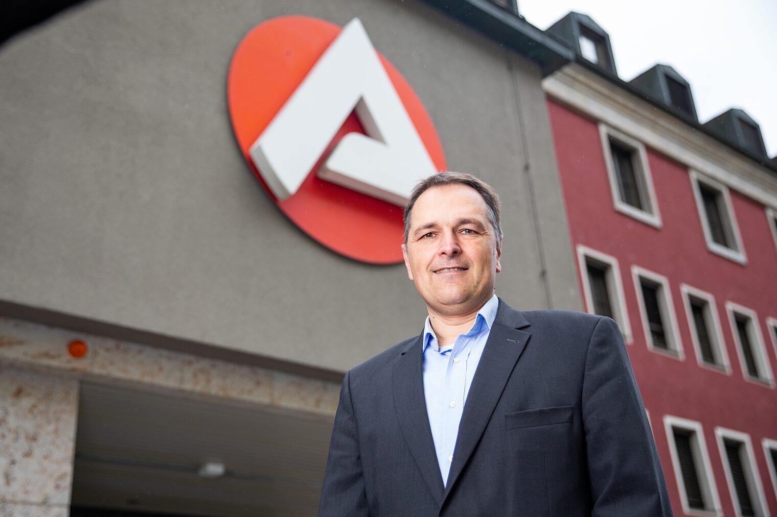 Porträt von Stefan Beil, Vorsitzender der Geschäftsführung der Agentur für Arbeit Würzburg, mit Logo der Agentur für Arbeit