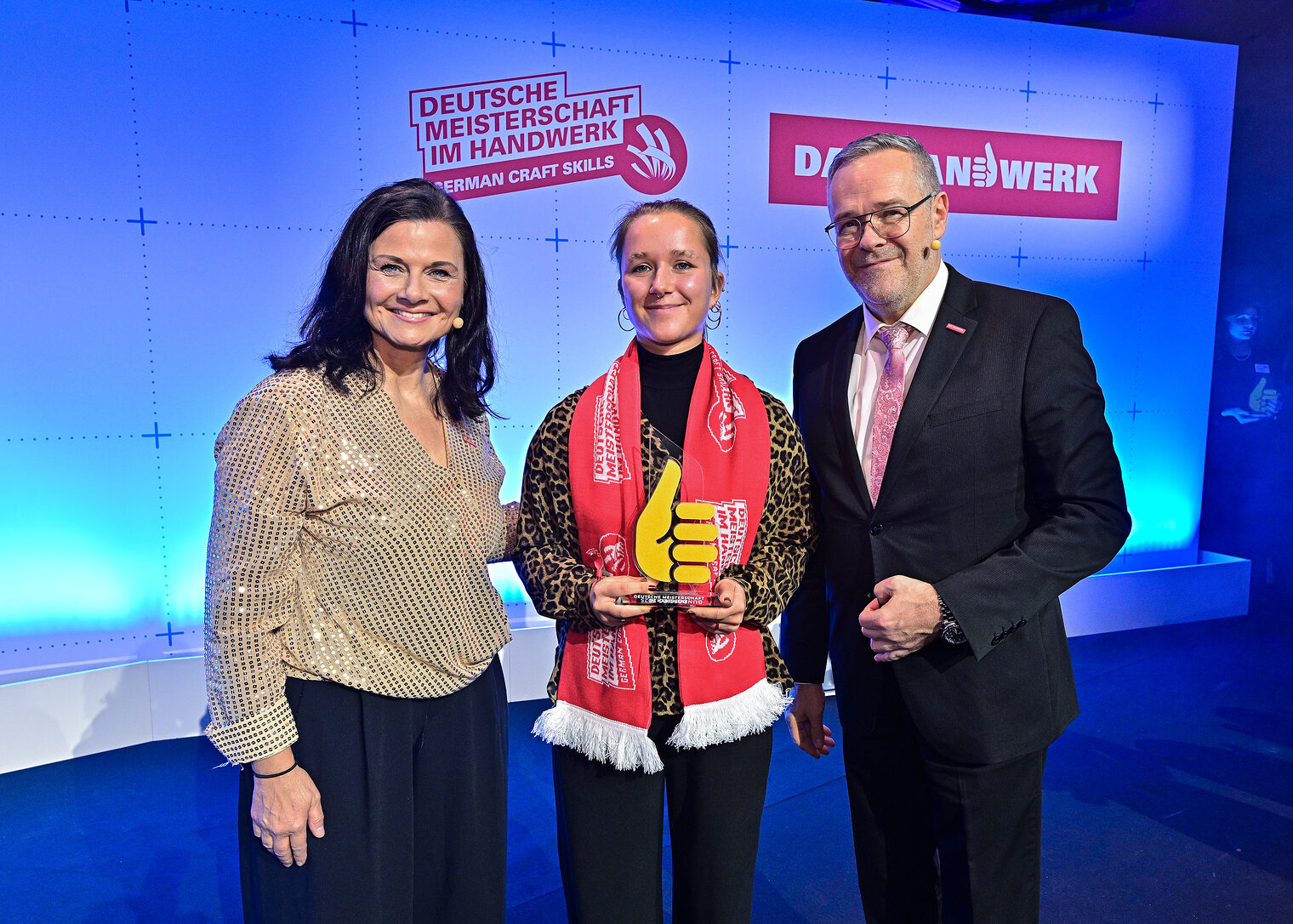 Gruppenfoto drei Personen auf Bühne